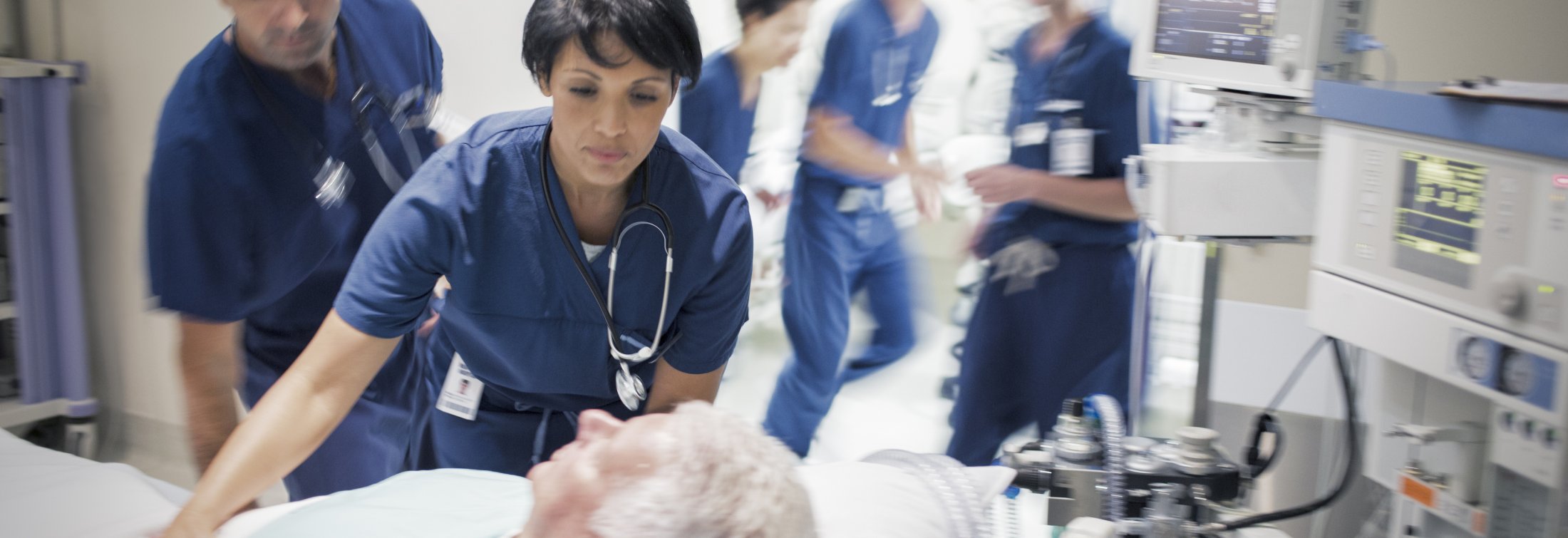 Two doctors preparing elderly patient before medical procedure.