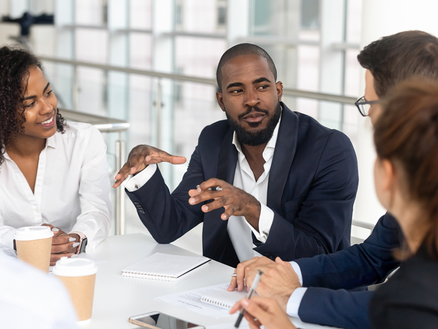 Man at table meeting with other executives